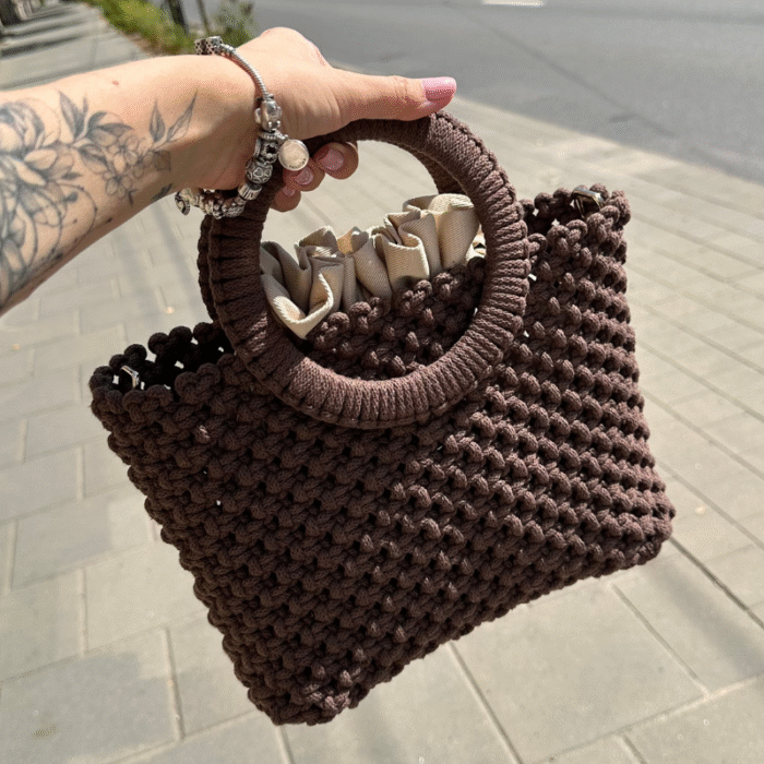 Rudos spalvos macrame rankinė Maia miesto fone