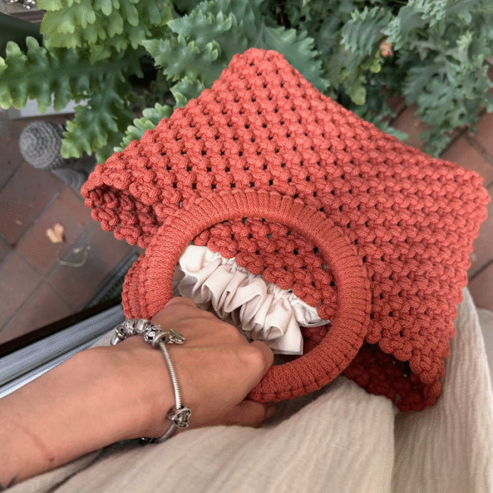Sodriai oranžinės spalvos macrame rankinė Maia rankoje